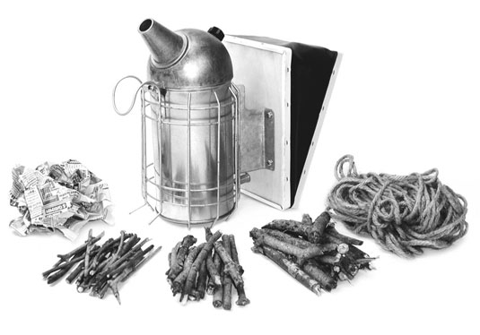 A smoker with all the ingredients is ready to load with paper, kindling of various size