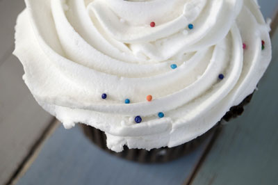 The texture of the faded colored wood tray under this cupcake adds interest. [Credit: Focal length: