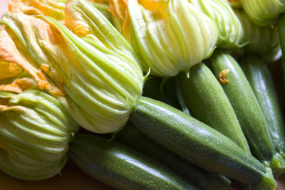Zucchini blossoms from the farmers’ market glow in a diffused light. [Credit: Focal length: 5